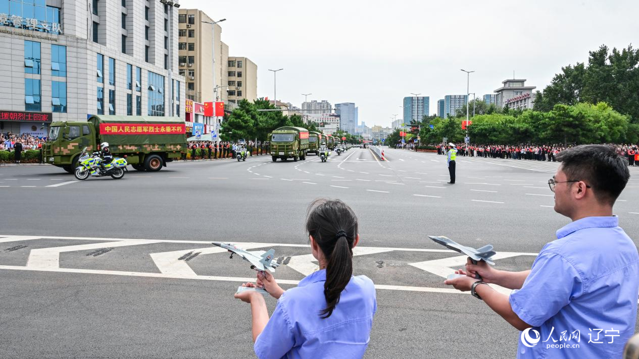 航空工業(yè)沈飛的青年技術(shù)人員拿著受閱戰(zhàn)機的模型迎接烈士遺骸。航空工業(yè)沈飛供圖